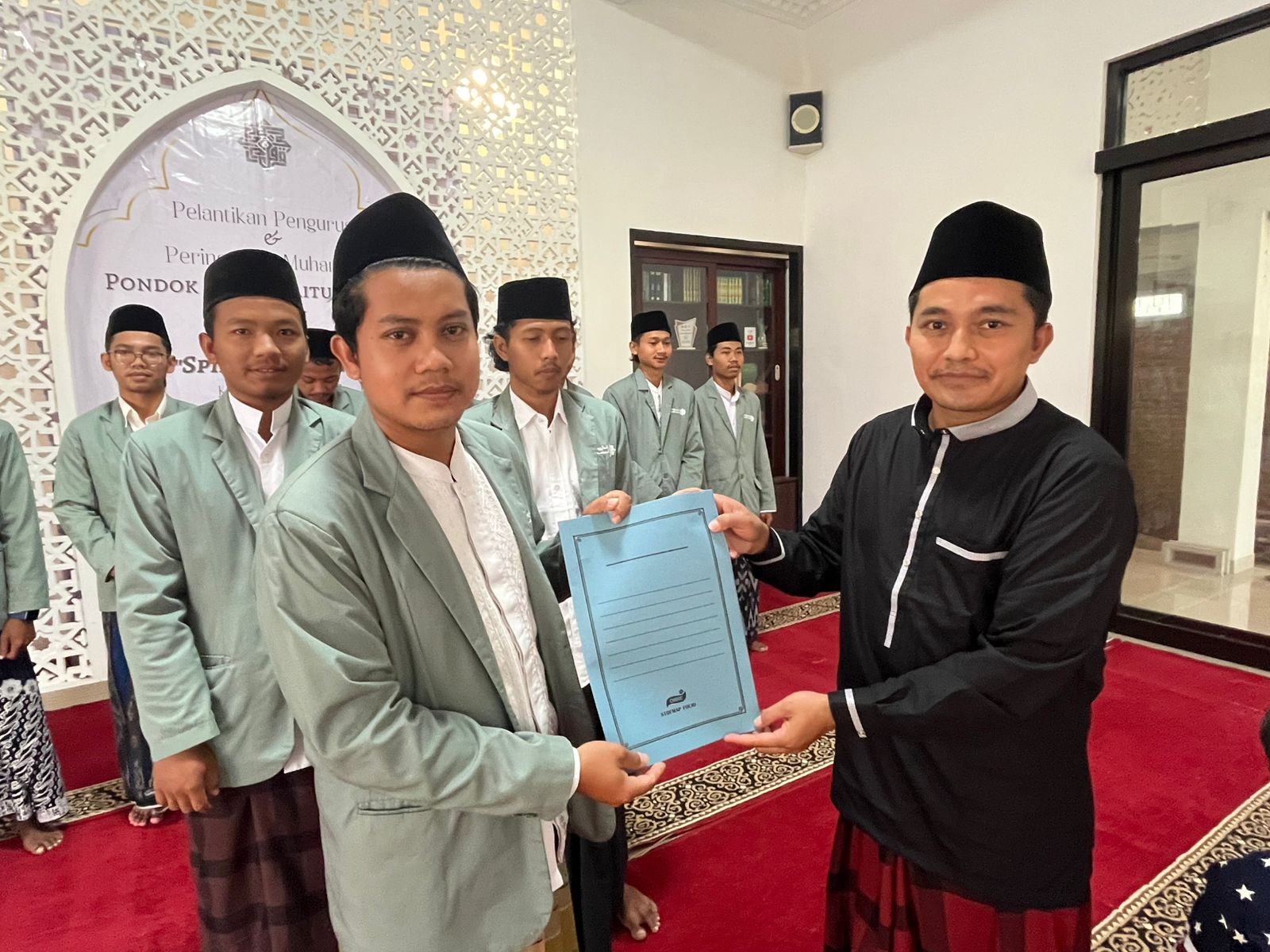 Penyerahan SK Lurah oleh Ketua Yayasan Al Farabi, Kiai Ach Dhofir Zuhry pada lurah baru.