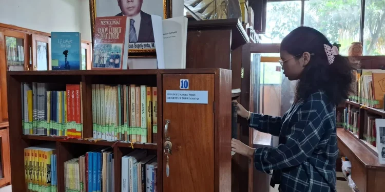 Seorang pustakawan menata ulang koleksi buku di Padepokan Sastra Tan Tular. Foto: Aisyah Nawangsari Putri