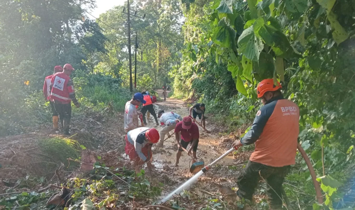 Petugas membersihkan jalan desa yang tertimbun longsor. Foto: BPBD Kabupaten Malang