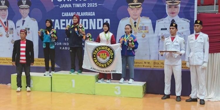 Atlet taekwondo Kabupaten Malang (memegang bendera) memenangkan medali perunggu di kelas poomsae individu putri. Foto: KONI Kabupaten Malang