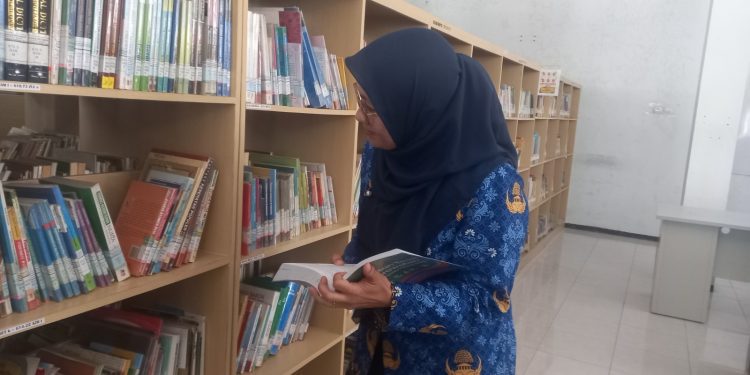Petugas mengecek koleksi buku di Perpustakaan Daerah Kabupaten Malang. Foto: Aisyah Nawangsari Putri