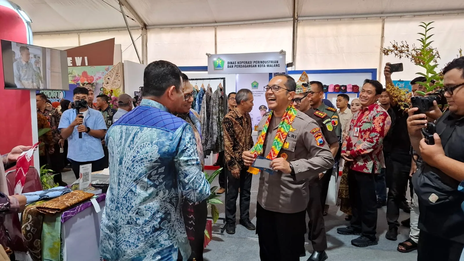Kapolres Batu AKBP Andi Yudha Pranata saat mencoba produk batik pelaku usaha di Batu Bisnis Festival 2025. Foto: Azmy