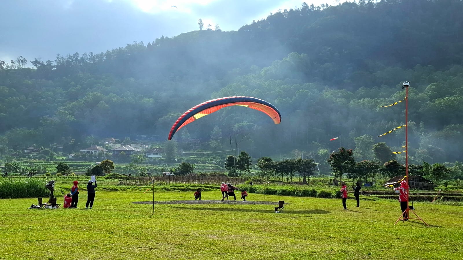 Atraksi atlet paralayang saat mendarat di Lapangan Songgomaruto. Foto: Azmy