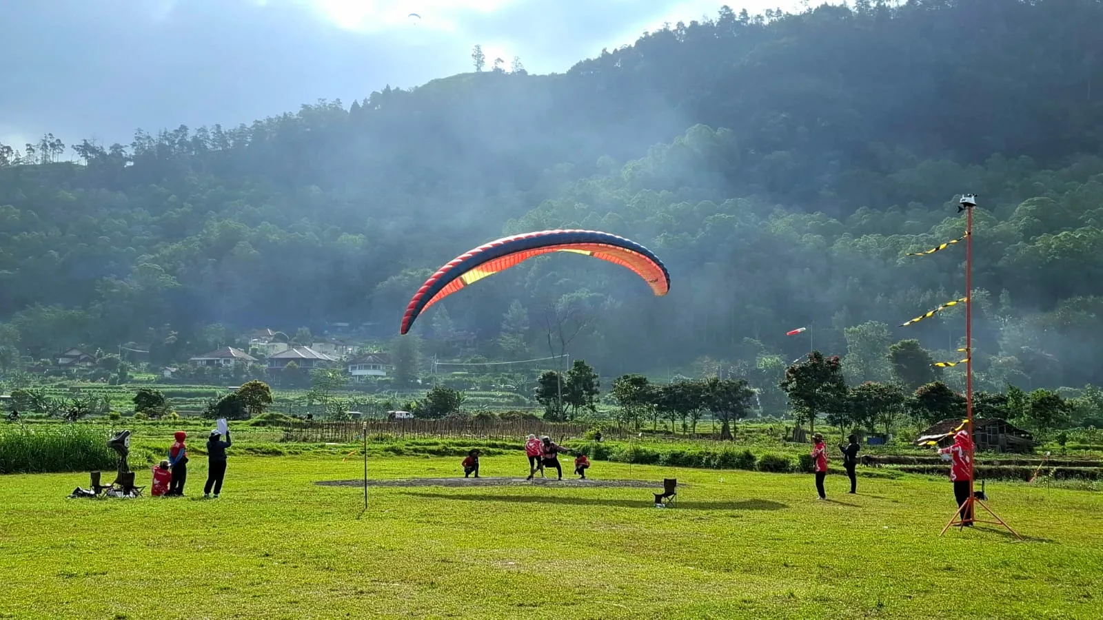 Atraksi atlet paralayang saat mendarat di Lapangan Songgomaruto. Foto: Azmy