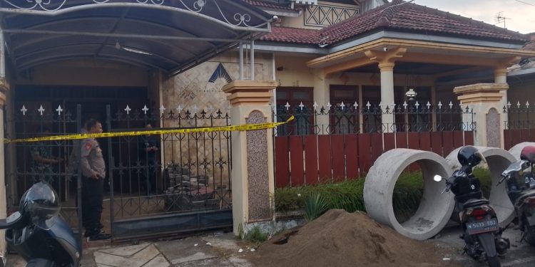 Petugas menjaga rumah warga Blimbing yang menjadi lokasi penemuan benda diduga granat. (Foto/M Sholeh)