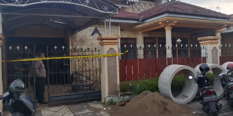 Petugas menjaga rumah warga Blimbing yang menjadi lokasi penemuan benda diduga granat. (Foto/M Sholeh)