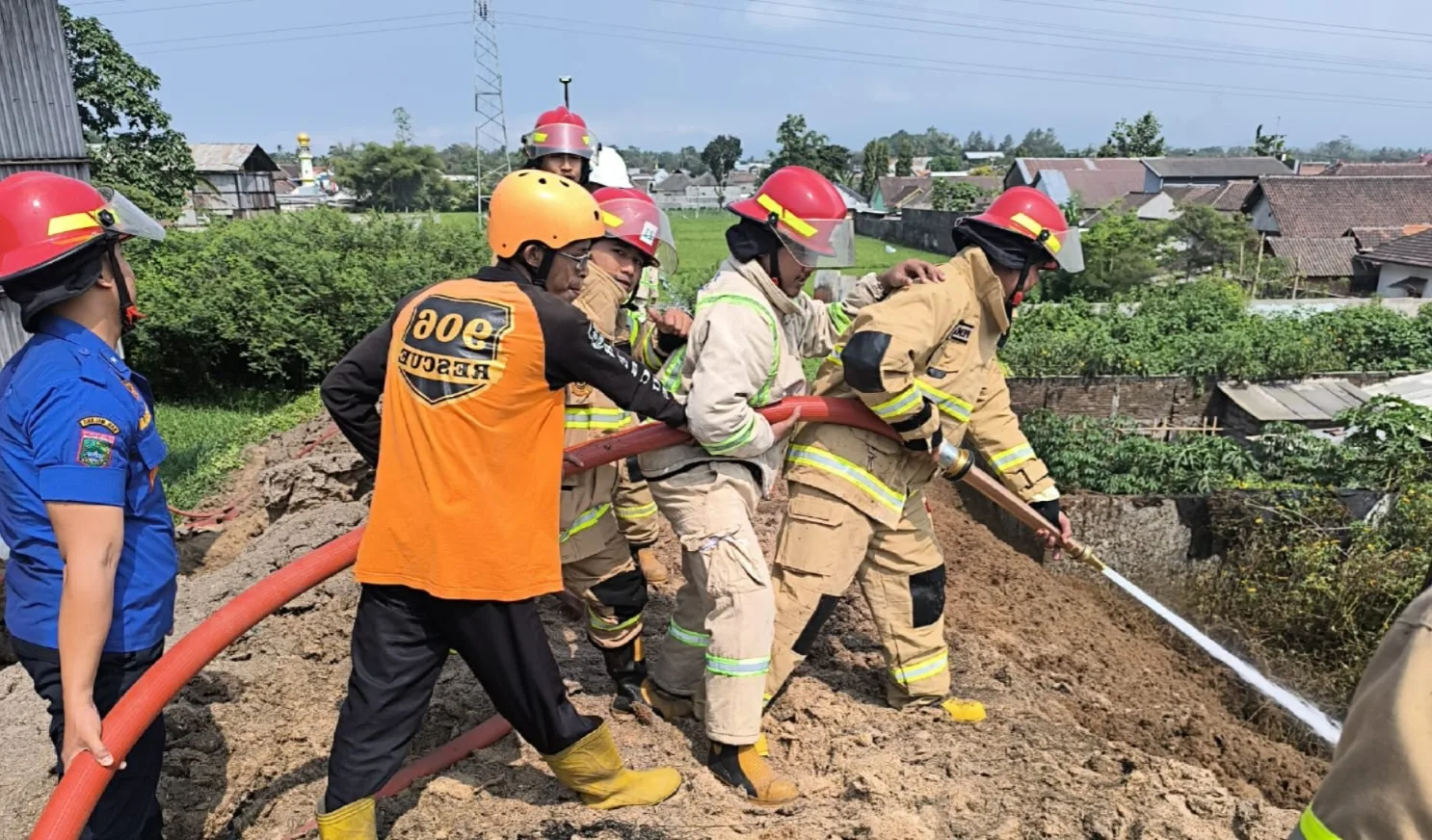 Petugas memadamkan api yang membakar tumpukan limbah tebu kering di PG Krebet Baru. Foto: Damkar Kabupaten Malang