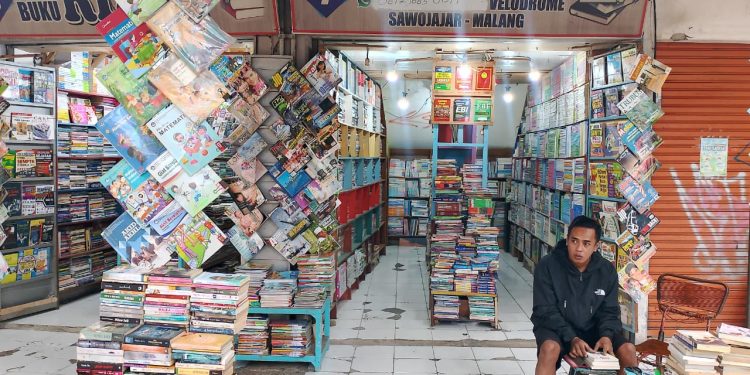 Sepi pembeli tak membuat pedagang Pasar Buku Bekas Velodrome Malang menyerah. Buku pelajaran, novel, hingga koleksi antik tetap tersaji demi literasi. Foto/Yuliana elvita sari