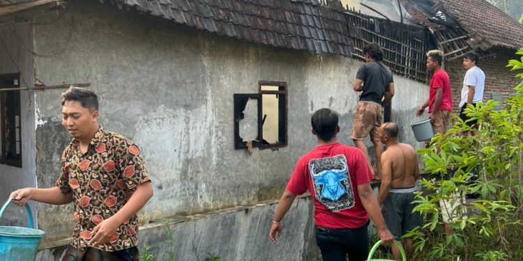 Warga bergotong royong memadamkan kebakaran rumah di Pakis. Foto: Polsek Pakis