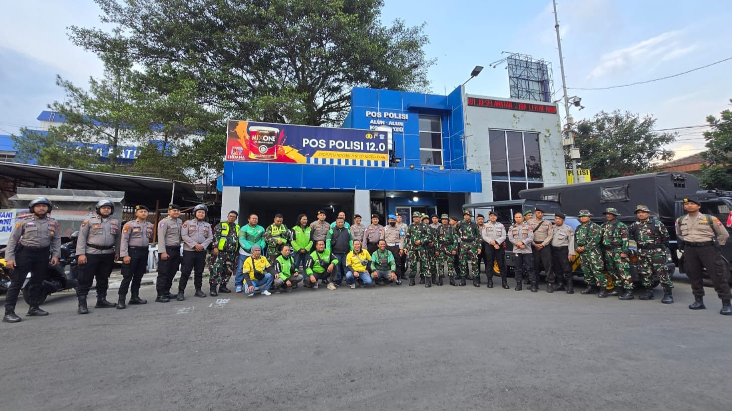 Driver ojol dan polisi di Kota Batu foto bersama setelah bersih-bersih. Foto/Azmy