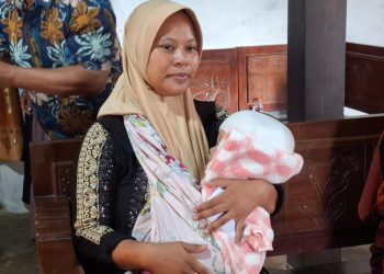 Suliantini menggendong bayinya, Queensa yang menderita hidrosefalus. Foto: Aisyah Nawangsari Putri