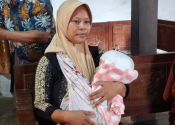 Suliantini menggendong bayinya, Queensa yang menderita hidrosefalus. Foto: Aisyah Nawangsari Putri
