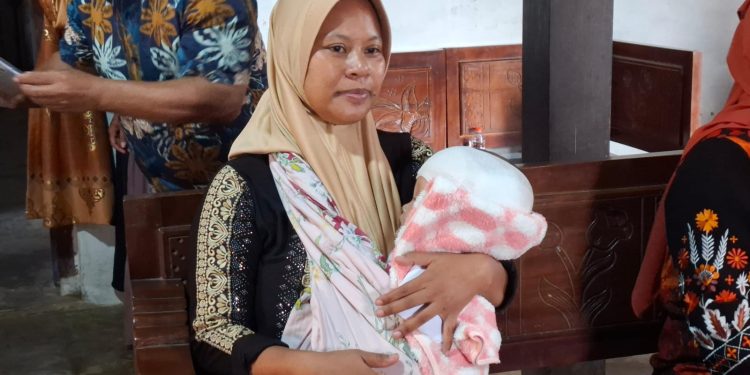 Suliantini menggendong bayinya, Queensa yang menderita hidrosefalus. Foto: Aisyah Nawangsari Putri