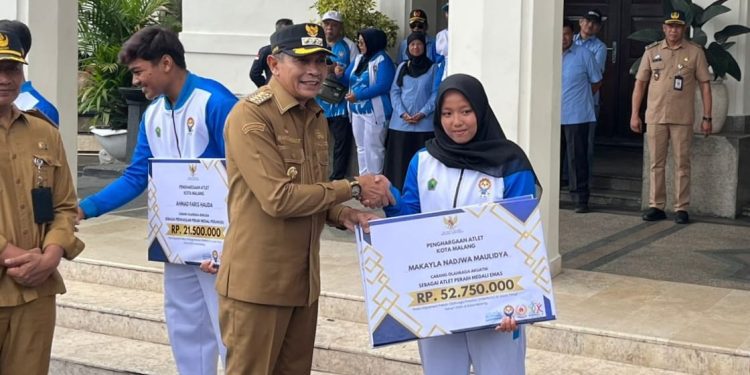 Wali Kota Malang, Wahyu Hidayat menyerahkan bonus atlet peraih medali Porprov Jatim. (Foto/M Sholeh)