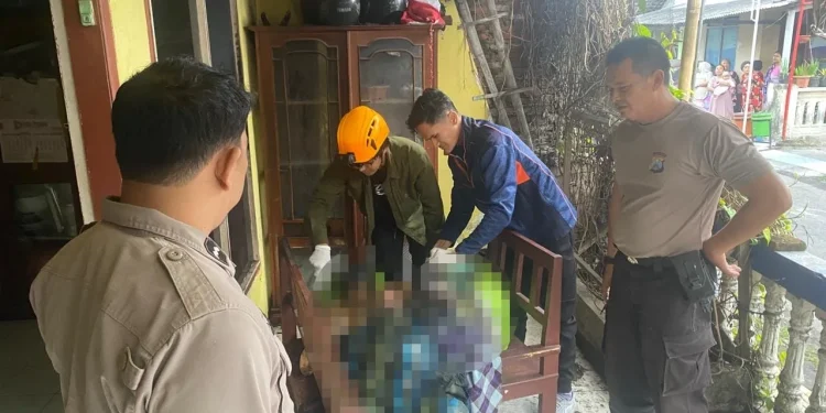 Petugas memeriksa jenazah lansia SM di lokasi kejadian. Foto: Polsek Pakis