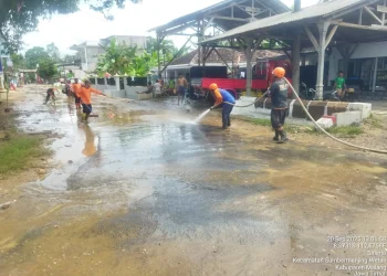 Petugas membersihkan dampak banjir di jalanan Desa Sitiarjo. Foto: BPBD Kabupaten Malang