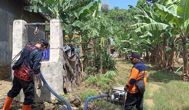 Petugas BPBD Kabupaten Malang menguras sumur warga Sitiarjo yang terdampak banjir. Foto: BPBD Kabupaten Malang