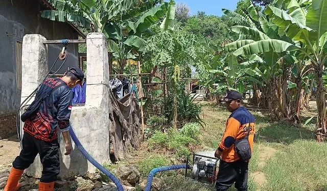 Petugas BPBD Kabupaten Malang menguras sumur warga Sitiarjo yang terdampak banjir. Foto: BPBD Kabupaten Malang