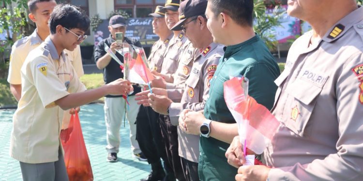 Aksi bagi-bagi bunga dan jeruk anak-anak sekolah MAN di Polres Batu. Foto: Azmy