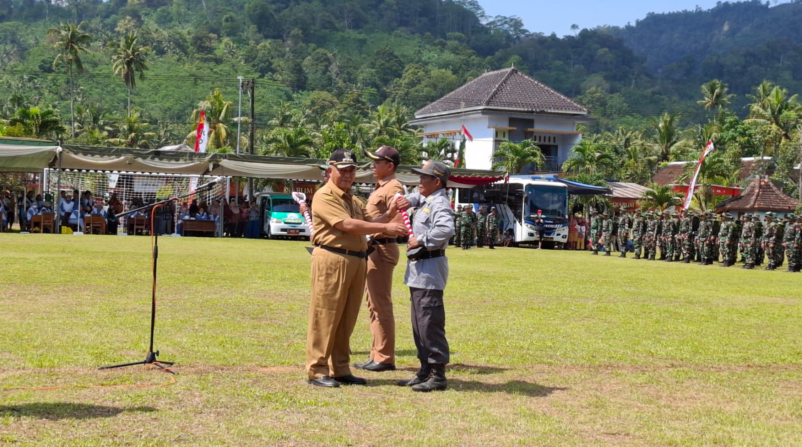 Bupati Malang, Sanusi menyerahkan alat kerja pada perwakilan Satlinmas saat pembukaan TMMD ke-126. Foto: Aisyah Nawangsari Putri