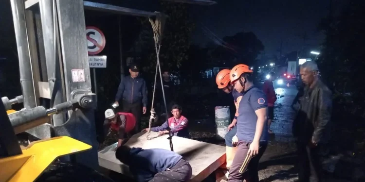 Pemasangan plat beton sementara di jalan yang ambles. Foto: BPBD Kabupaten Malang