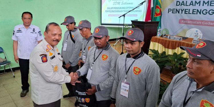 Kepala Bidang Ketentraman dan Ketertiban Umum Satpol PP Provinsi Jawa Timur, Muhammad Tabrani serahkan seminar kit kepada peserta. Foto: Aisyah Nawangsari Putri