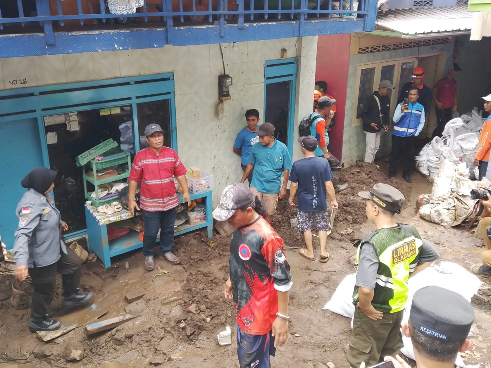 Warga, relawan dan petugas kerja bakti memberisihkan sisa lumpur dan matrial reruntuhan trotoar Jembatan Embong Brantas yang ambrol. (Foto/M Sholeh)