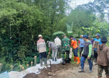Plengsengan ambrol, petugas dan warga bekerja bakti membuat penahan jalan sementara. Foto: BPBD Kabupaten Malang
