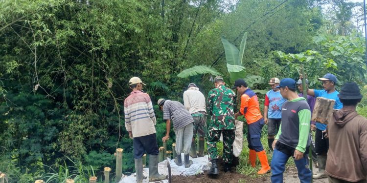 Plengsengan ambrol, petugas dan warga bekerja bakti membuat penahan jalan sementara. Foto: BPBD Kabupaten Malang