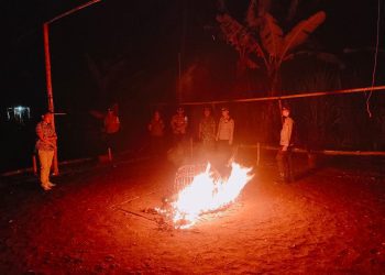 Petugas membakar kurungan ayam yang ditemukan di lokasi judi sabung ayam. Foto: Polres Malang