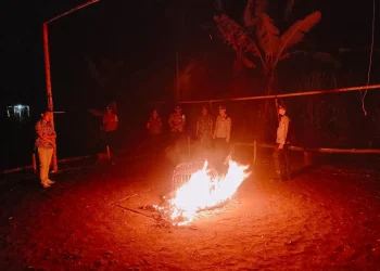 Petugas membakar kurungan ayam yang ditemukan di lokasi judi sabung ayam. Foto: Polres Malang