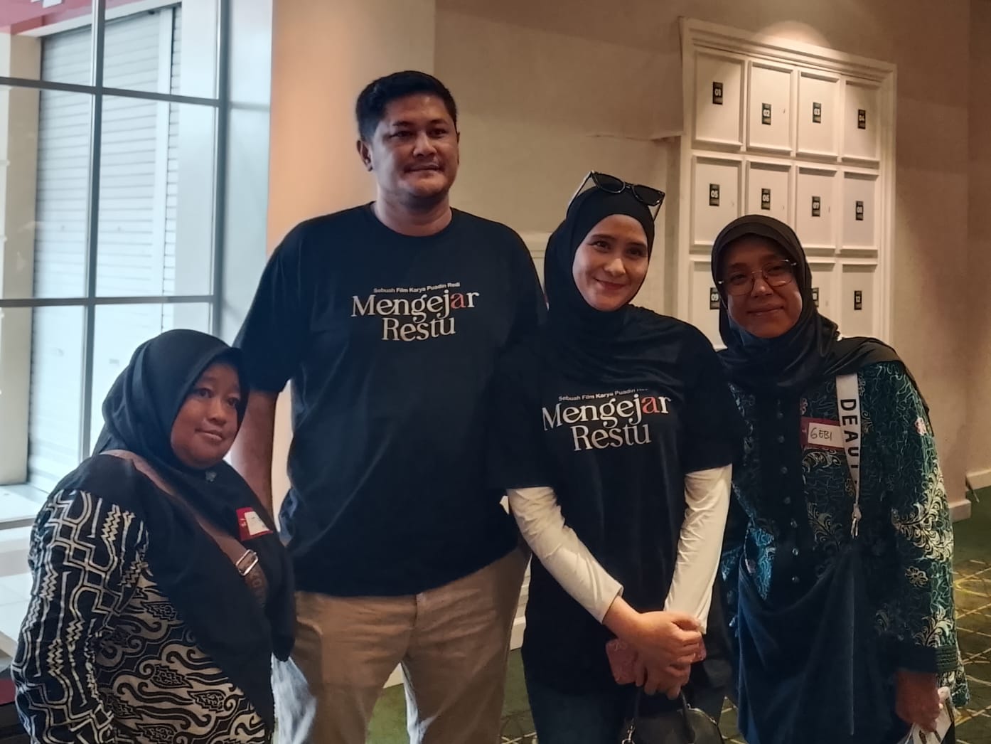 Sutradara film Mengejar Restu, Puadin Redi dan istri Ryana Dea foto bersama penonton di Bioskop Araya XXI Malang. (Foto/M Sholeh)