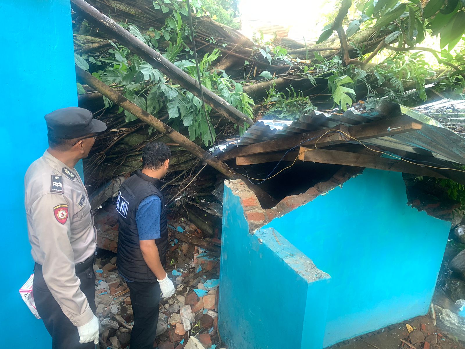 Atap dan tembok kamar mandi umum runtuh tertimpa pohon beringin. Foto: Polsek Lawang