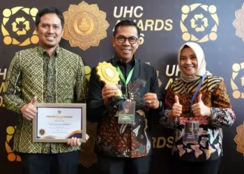 Wali Kota Batu Nurochman (tengah) didampingi Kadinkes Aditya Prasaja saat menerima penghargaan UHC Awards 2025. Foto: Prokopim KWB