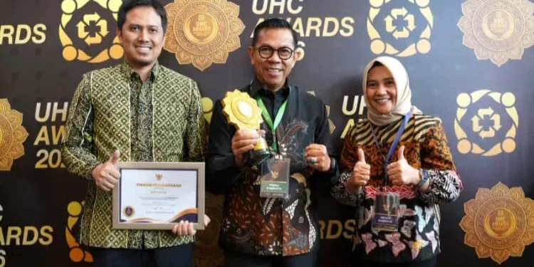 Wali Kota Batu Nurochman (tengah) didampingi Kadinkes Aditya Prasaja saat menerima penghargaan UHC Awards 2025. Foto: Prokopim KWB
