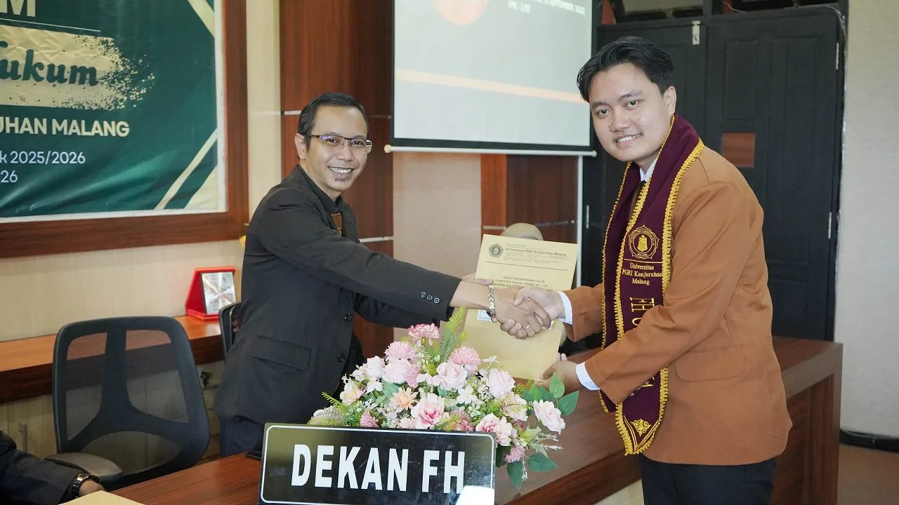 Dekan FH Unikama, Darajatun Indra Kusuma Wijaya, S.H, M.H (kiri) menyerahkan dokumen yudisium kepada perwakilan mahasiswa lulusan terbaik. /Foto: Dok. Unikama.