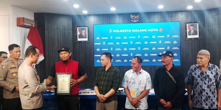 Kapolresta Malang Kota, Kombes Pol Putu Kholis Aryana berikan penghargaan kepada warga yang berani membubarkan aski balap liar. (Foto/M Sholeh)