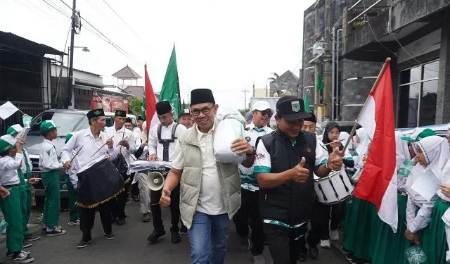 Wali Kota Batu Nurochman saat ikut membanu menggotong bendera raksasa berlambang NU dalam peringatan 1 Abad NU di Kota Batu. Foto: Diskominfo Kota Batu