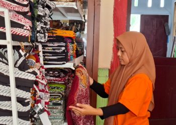 Penanggung jawab Griya Batik Seng, Evi Wahyu Astutik memeriksa stok kain batik di galeri. Foto: Aisyah Nawangsari Putri