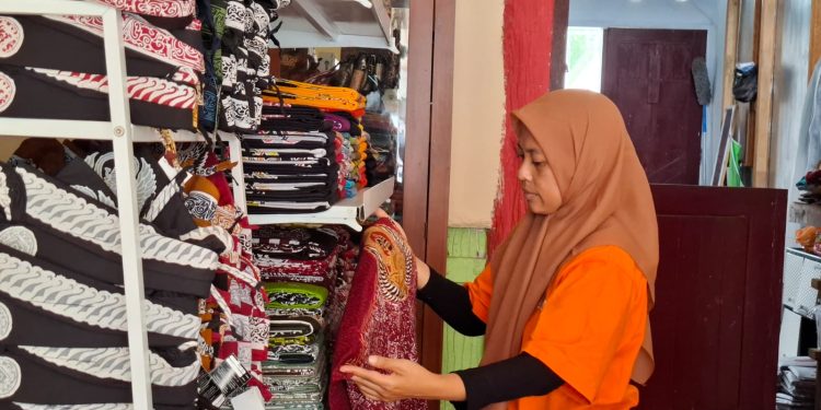 Penanggung jawab Griya Batik Seng, Evi Wahyu Astutik memeriksa stok kain batik di galeri. Foto: Aisyah Nawangsari Putri