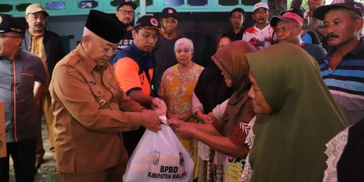 Bupati Malang, Sanusi menyerahkan bantuan kepada warga terdampak angin puting beliung di Bantur. Foto: Pemkab Malang