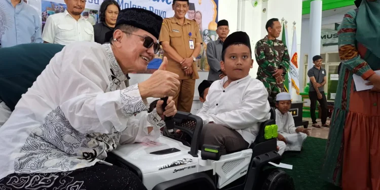 Komut PT ACA, Iwan Kurniawan (kiri) memberi hadiah mobil mainan aki kepada Wafi Mafaza. Foto: Aisyah Nawangsari Putri
