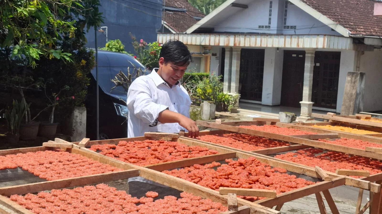 Azmi menata ulang rengginang yang dijemur. Foto: Aisyah Nawangsari Putri