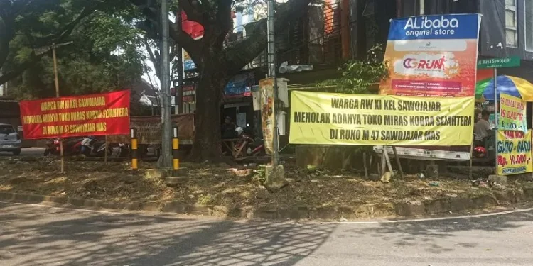 Banner penolakan warga atas keberadaan toko miras di kawasan Sawojajar, Kota Malang. (Foto/M Sholeh)