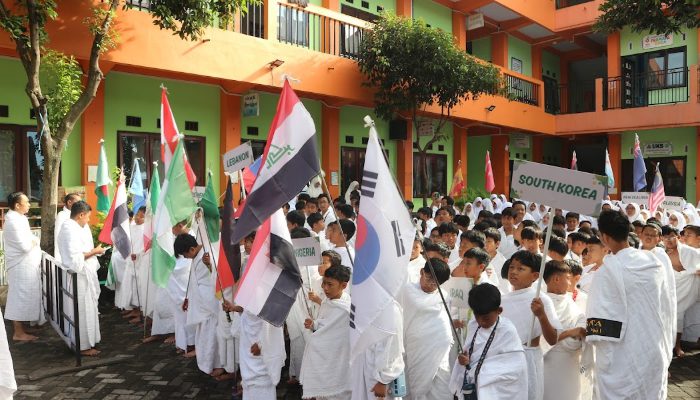 Siswa SDIT Insan Permata membawa atribut dan bendera dari berbagai negara saat mengikuti kegiatan manasik haji./Foto: Dok. SDIT Insan Permata Malang.