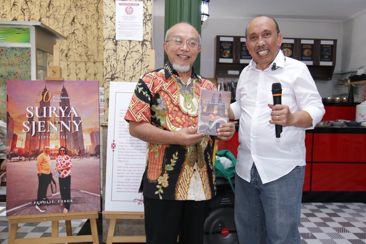 Surya Burhanuddin (kanan) menyerahkan buku kepada perwakilan Ikatan Keluarga Minang (IKAM) Sehati Dr dr Achdiat Agoes, Sp.S.