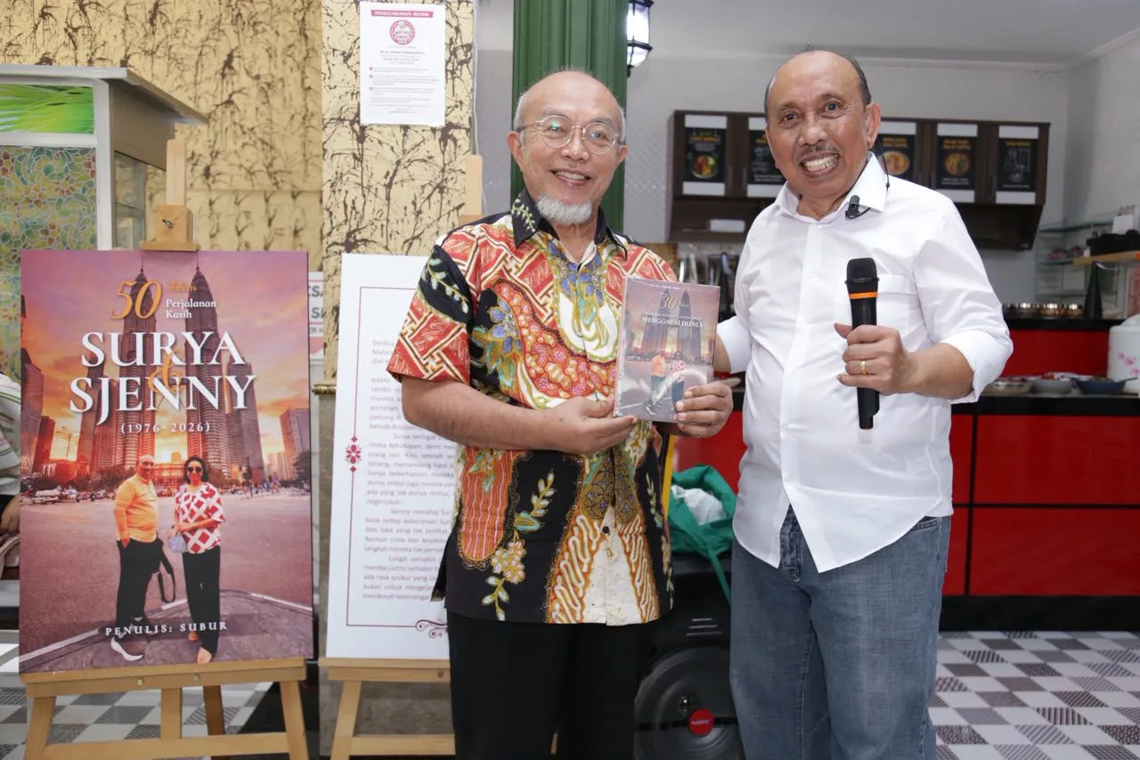 Surya Burhanuddin (kanan) menyerahkan buku kepada perwakilan Ikatan Keluarga Minang (IKAM) Sehati Dr dr Achdiat Agoes, Sp.S.