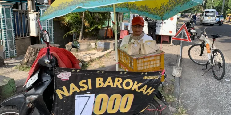 Aan Sjahrir, 55 tahun, saat menjual nasi bungkusan seharag Rp7 ribu. Foto/Irham Thoriq