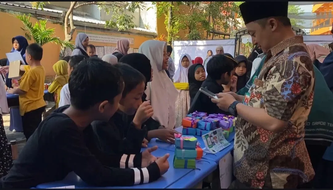 Siswa SDIT Insan Permata menjelaskan produk inovasi hasil pengolahan limbah jelantah berupa sabun dan lilin kepada pengunjung yang datang di acara Gelar Karya. /Foto: Dok. SDIT Insan Permata.
