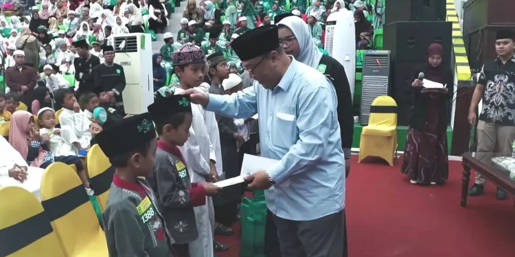 Rektor Unisma Prof. Junaidi saat memberikan santunan kepada ribuan anak yatim dan dhuafa. Foto: Azmy